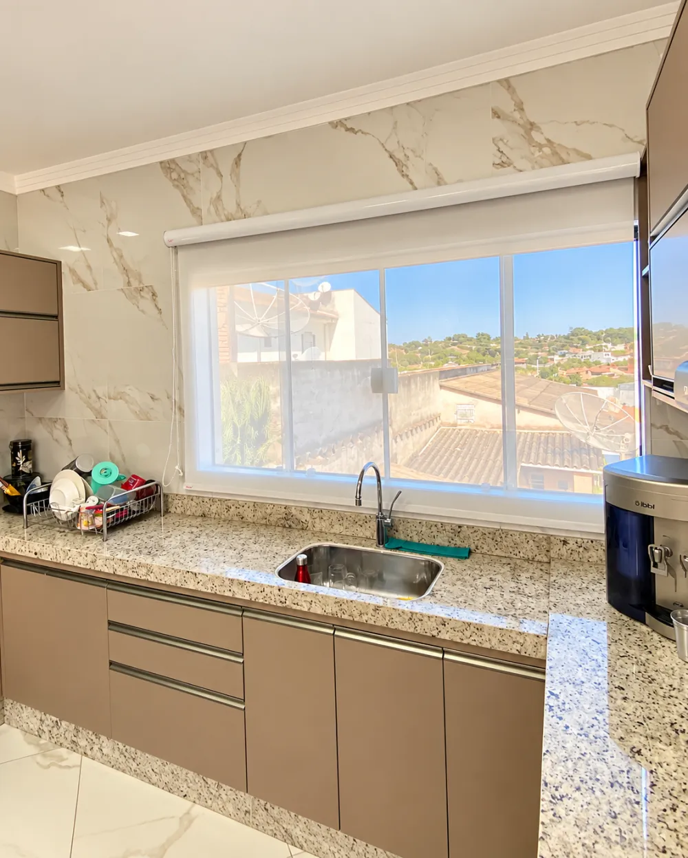 Cozinha clara com janela ampla sobre a bancada